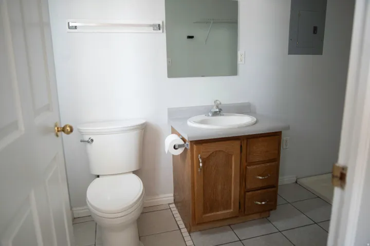 Bathroom vanity with a wood-finish cabinet, integrated sink, and laminate countertop