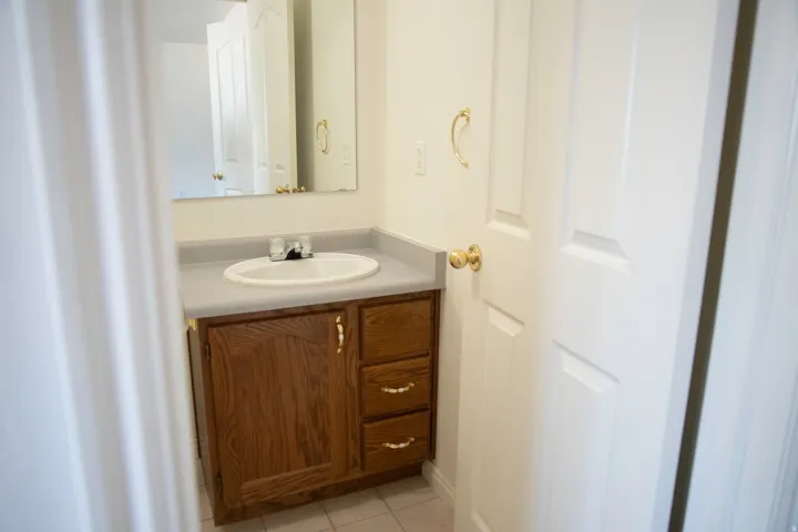 Bathroom featuring a wood vanity with a light-colored countertop and an integrated sink