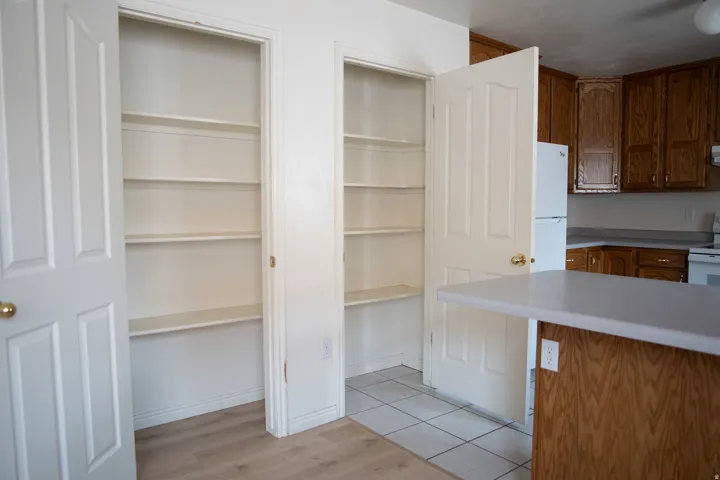 Dual pantry closets with multiple shelves, providing extensive storage