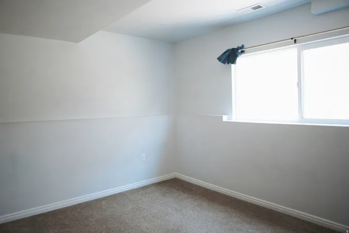 Spacious room featuring neutral carpeting and white baseboards