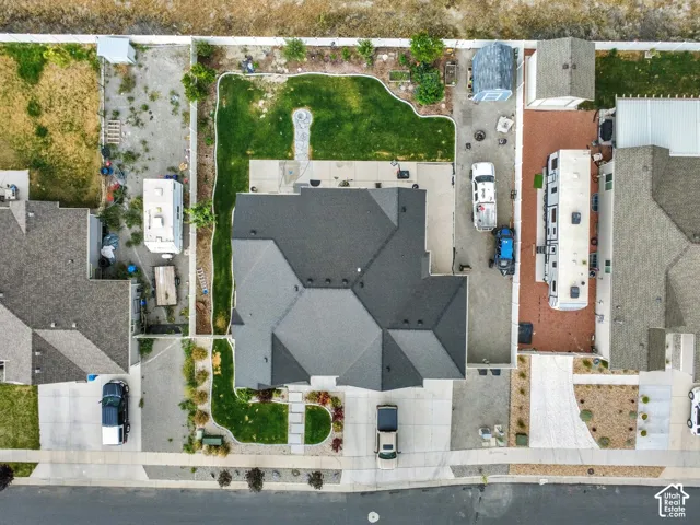 Contemporary residence featuring a multi-gabled dark shingle roof, a concrete driveway, and a manicured lawn