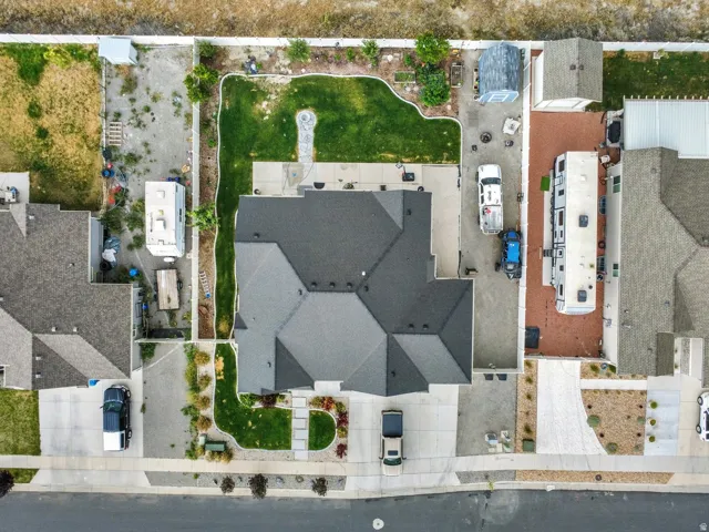 Contemporary residence featuring a multi-gabled dark shingle roof, a concrete driveway, and a manicured lawn