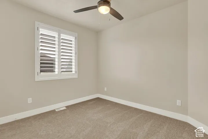 Neutral-toned interior with a window featuring white plantation shutters