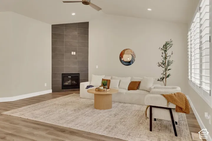 Spacious room featuring vaulted ceilings, recessed lighting, and wood-finish flooring