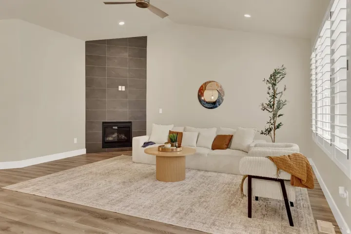 Spacious room featuring vaulted ceilings, recessed lighting, and wood-finish flooring