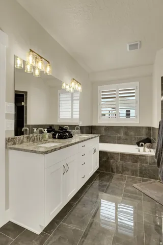 Dual vanity with white cabinetry, stone countertop, and two rectangular undermount sinks