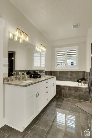 Dual vanity with white cabinetry, stone countertop, and two rectangular undermount sinks