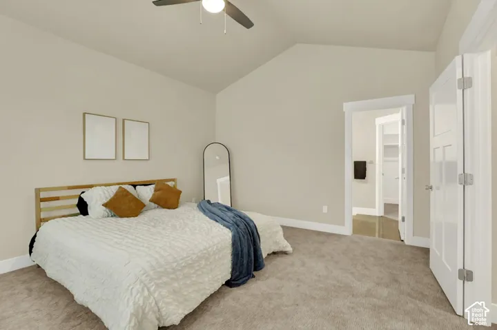 Bedroom featuring vaulted ceilings, carpeted flooring, a ceiling fan with integrated lighting, and white trim throughout