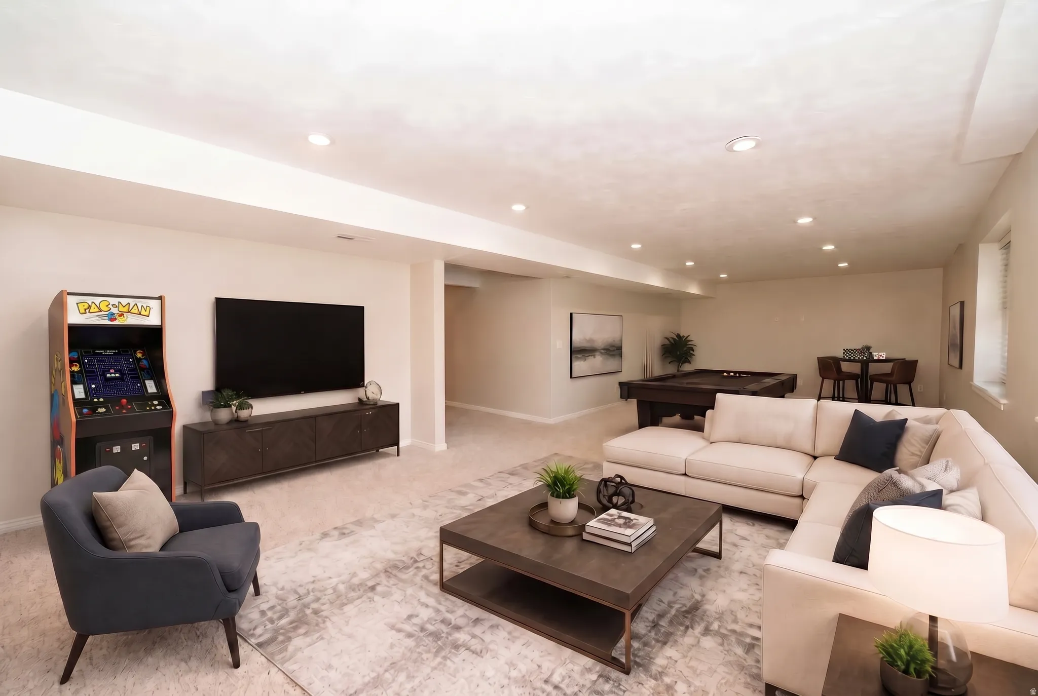 Recessed lighting illuminates the open-concept living space with light-colored carpeting