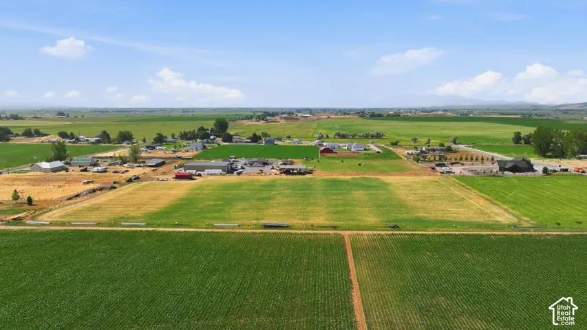 Expansive agricultural landscape featuring cultivated fields and scattered farm structures