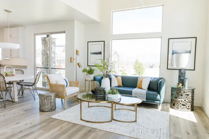 Open-concept living area featuring high ceilings, light wood-finish flooring, and large windows