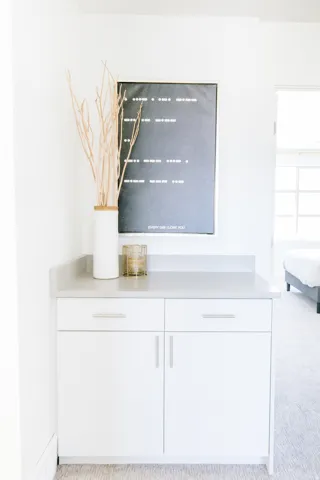 Built-in white cabinetry with two drawers and two cabinet doors, topped with a light gray countertop and matching backsplash