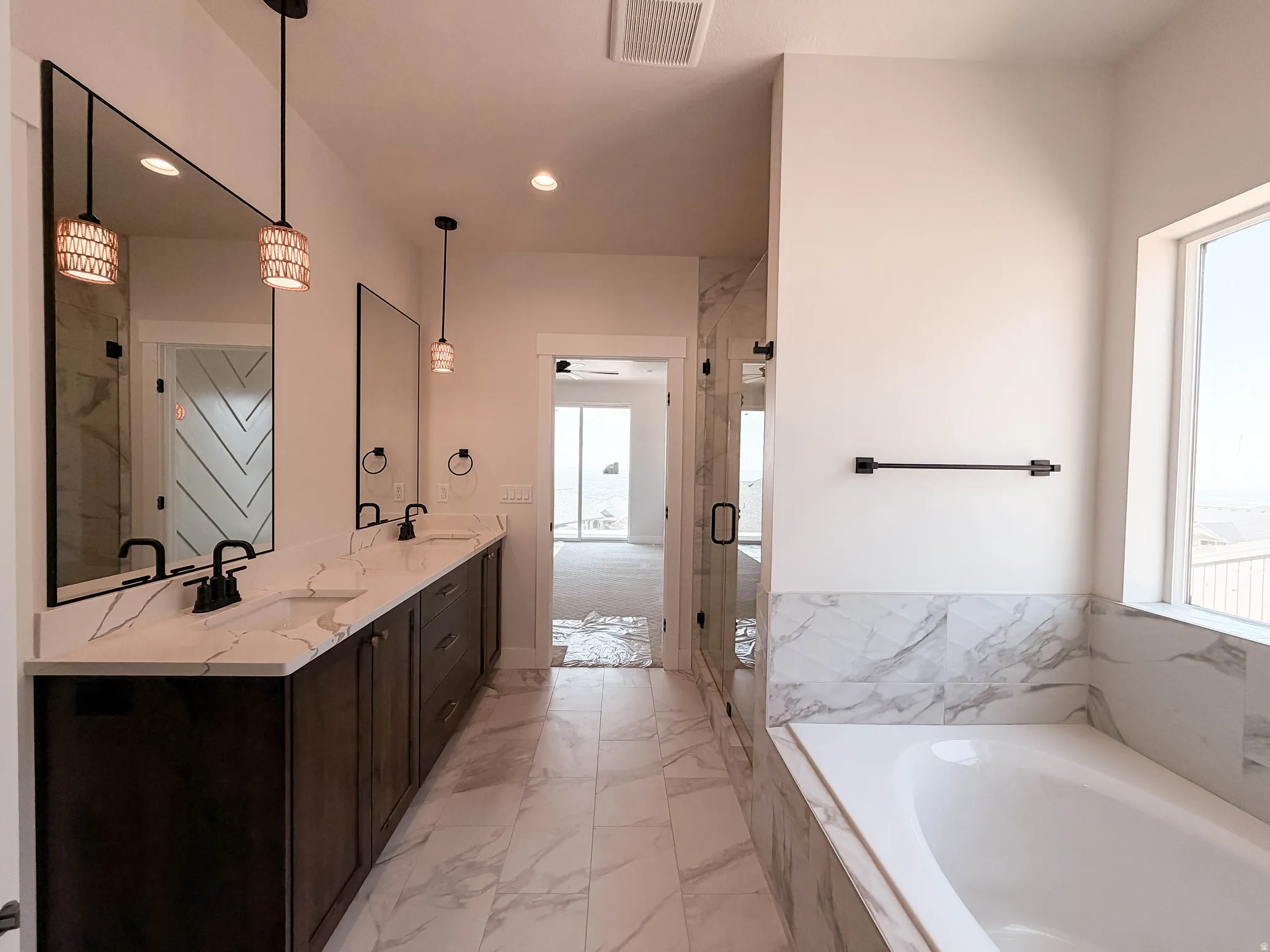 Spacious bathroom featuring a double vanity with stone countertops, undermount sinks, and dark cabinetry