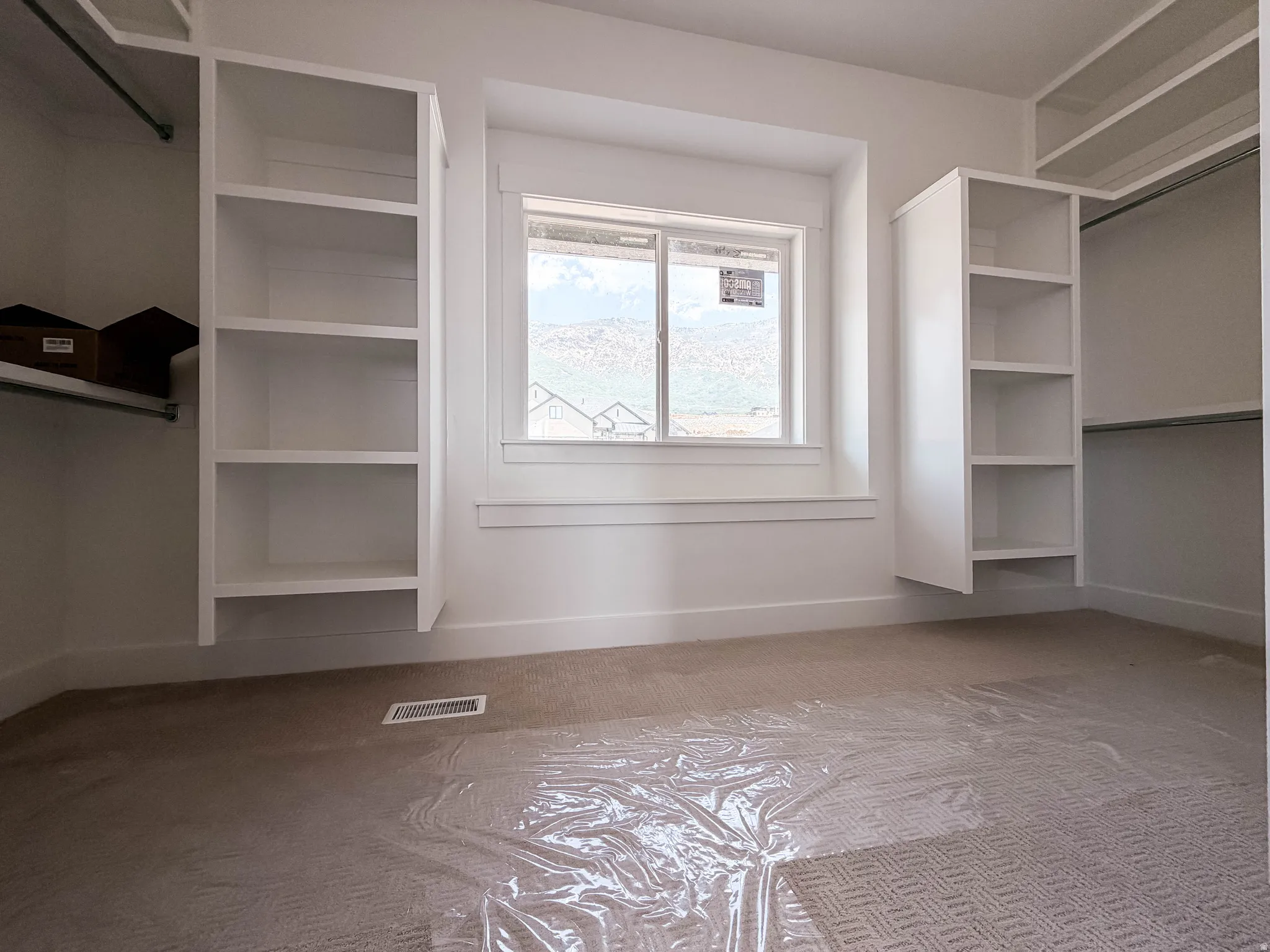 Built-in shelving units flank a window with mountain scenery