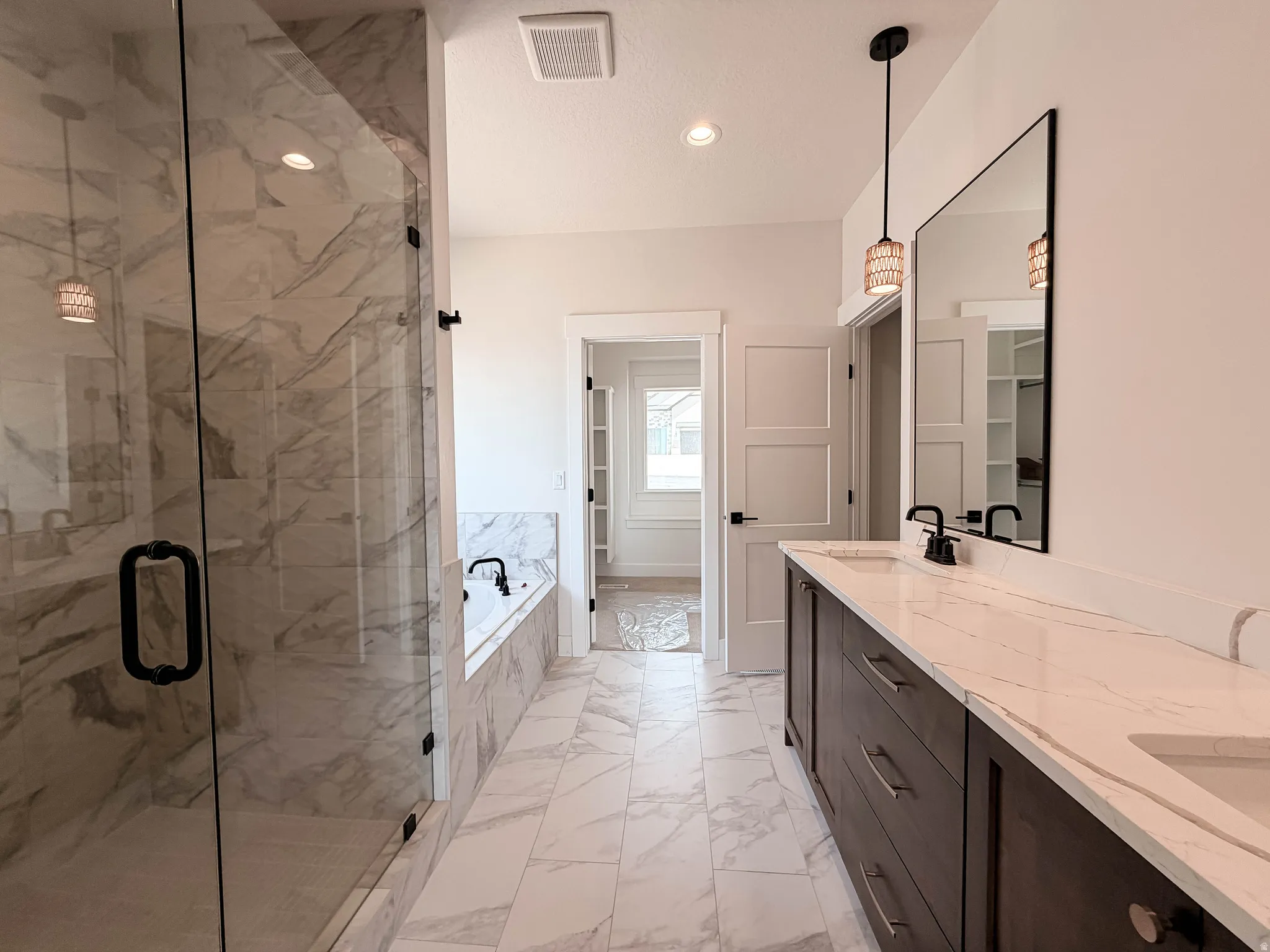 Spacious bathroom featuring a dual vanity with dark wood-finish cabinetry and white countertops