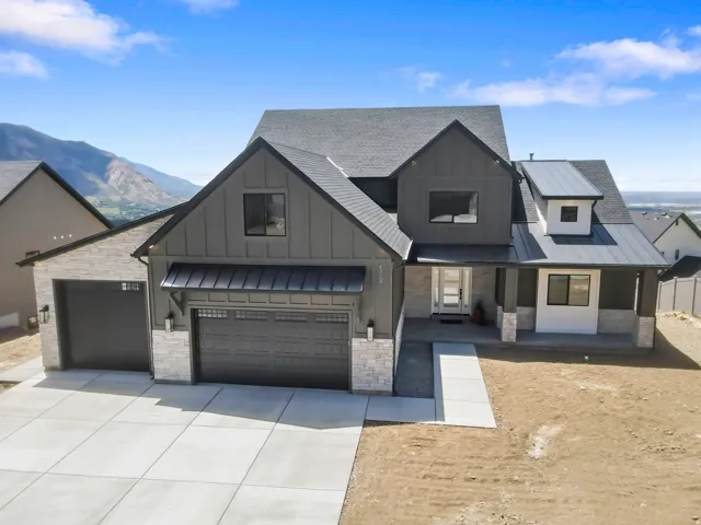 Contemporary exterior featuring vertical siding, stone accents, and a multi-gabled roofline