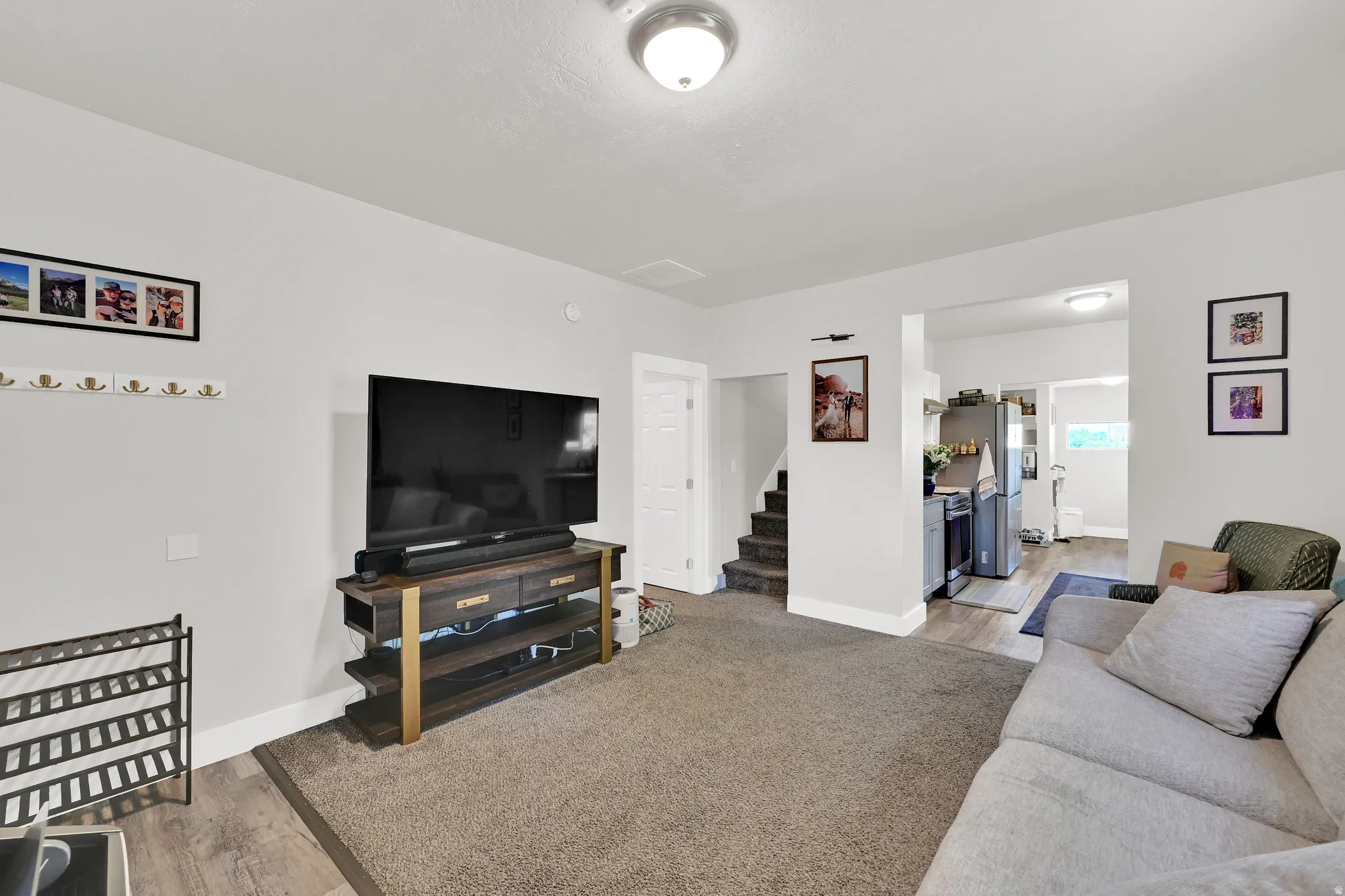 Open-concept living space featuring light gray walls and wood-finish flooring