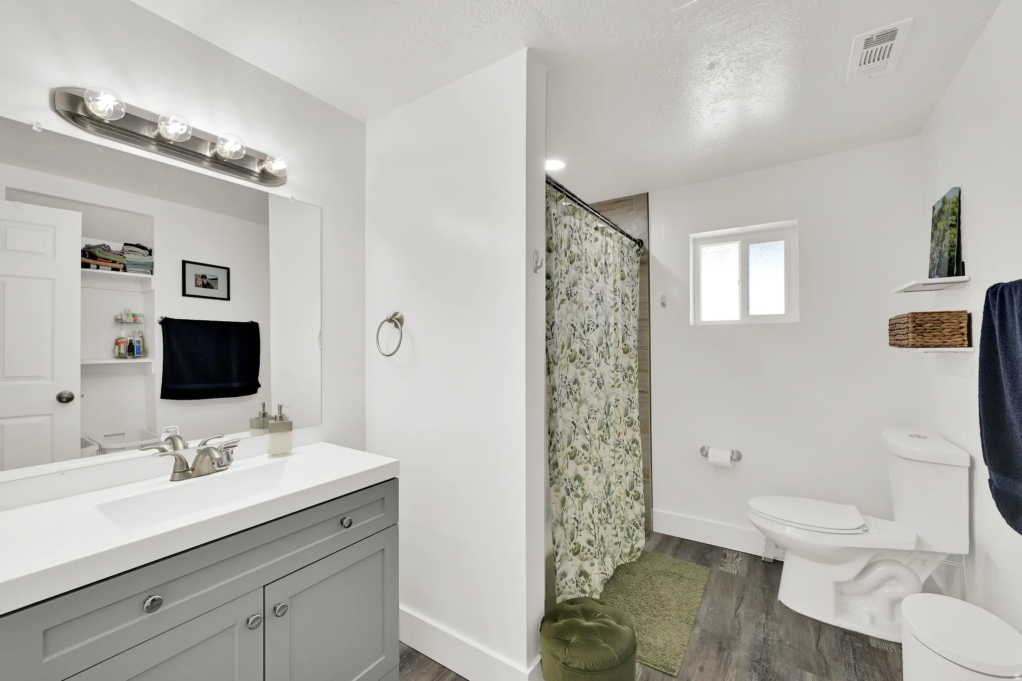 Bathroom featuring a single vanity with gray cabinetry, a white countertop, and a brushed nickel faucet