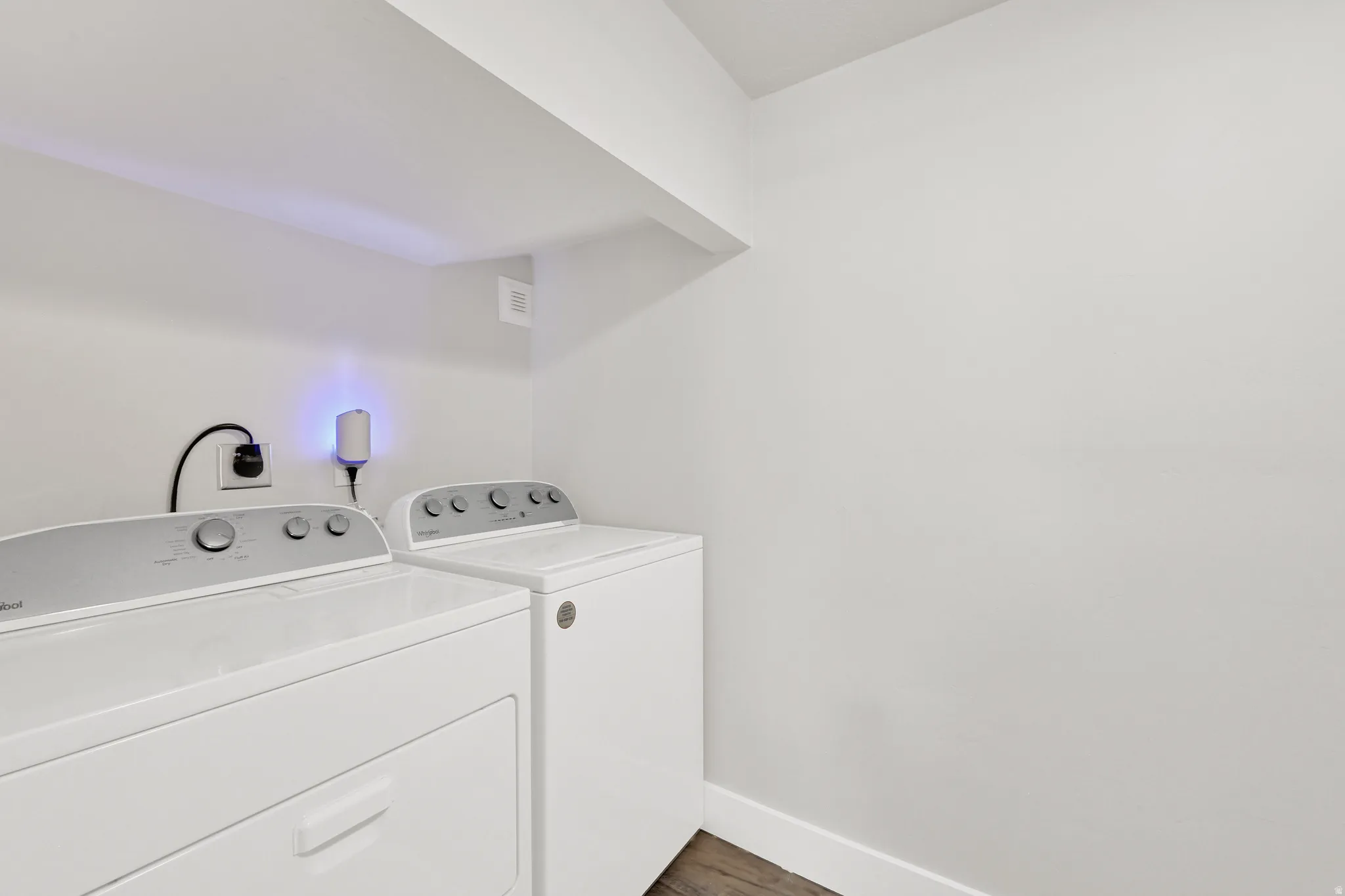 Dedicated laundry area featuring a white top-load washing machine and a white front-load dryer