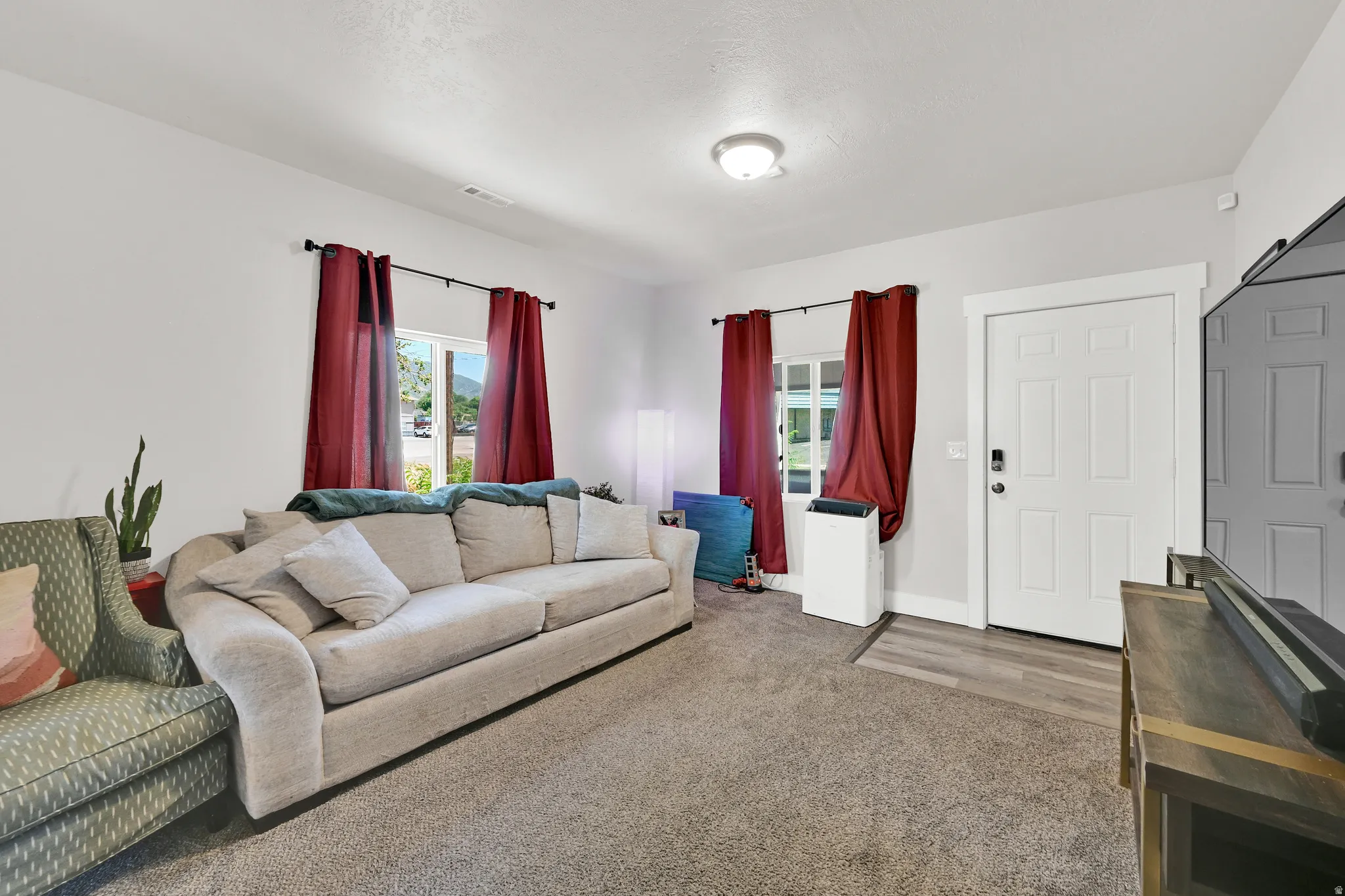 Open concept living space featuring neutral gray carpeting and light gray wall paint