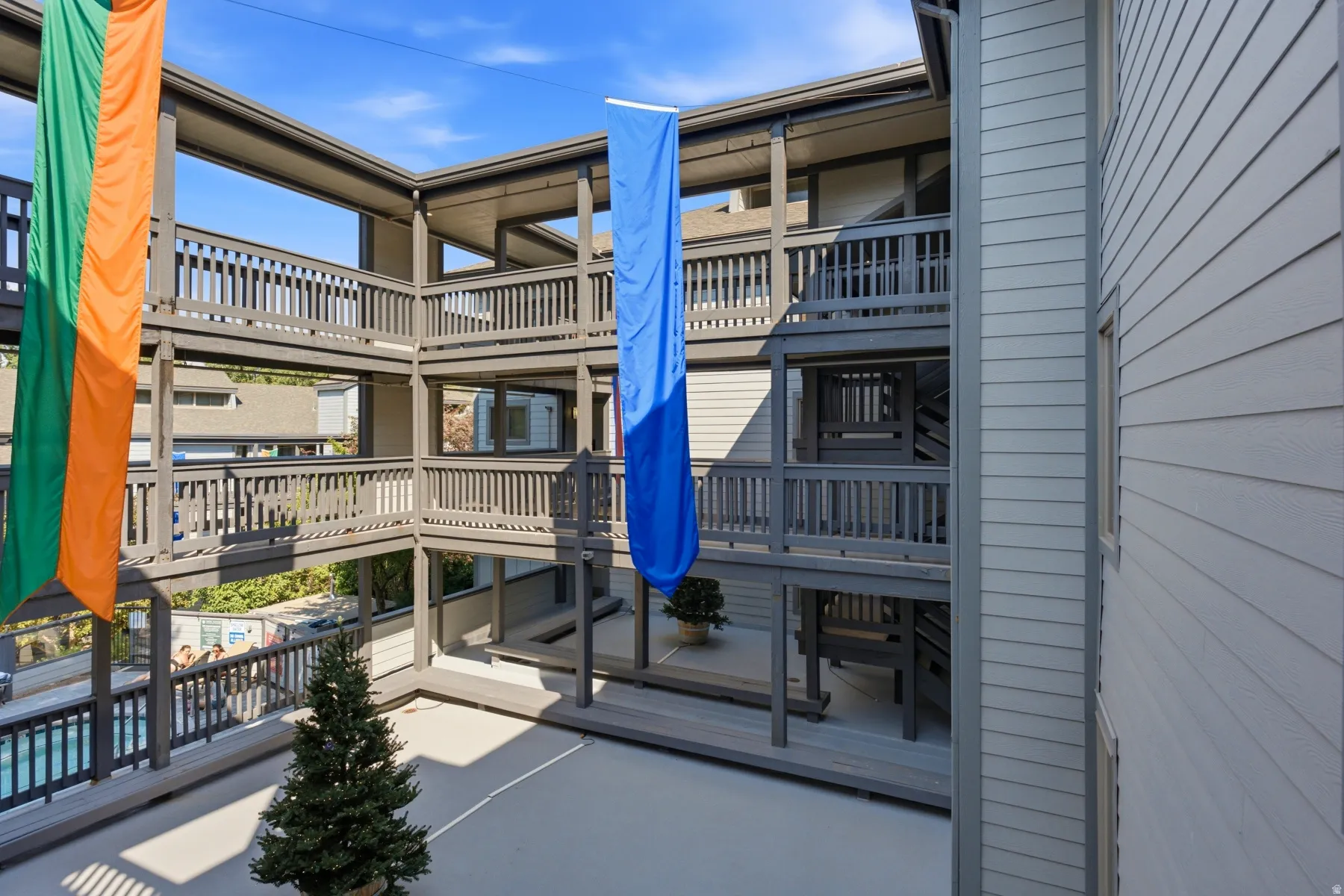 Multi-level building exterior featuring horizontal siding and dark gray railings