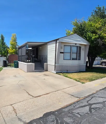 Single-story residence featuring siding exterior, a covered porch with metal railing, and a bay window