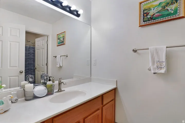 Bathroom vanity with a rectangular undermount sink, brushed nickel faucet, and a large wall-mounted mirror