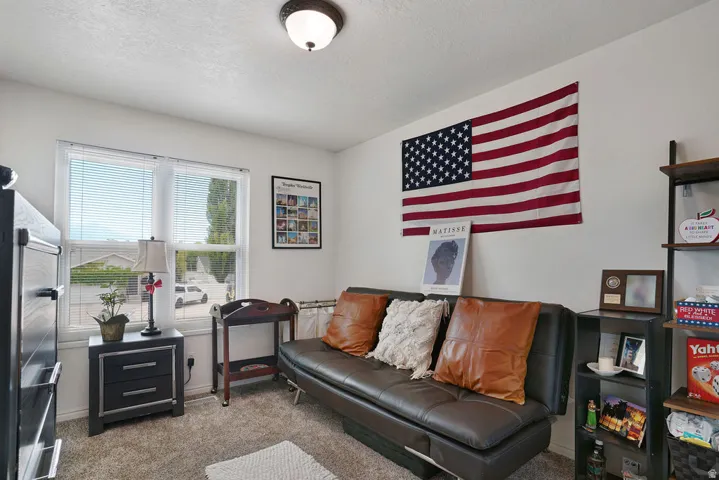 Room featuring light-toned walls, a double window with blinds, and carpeted flooring