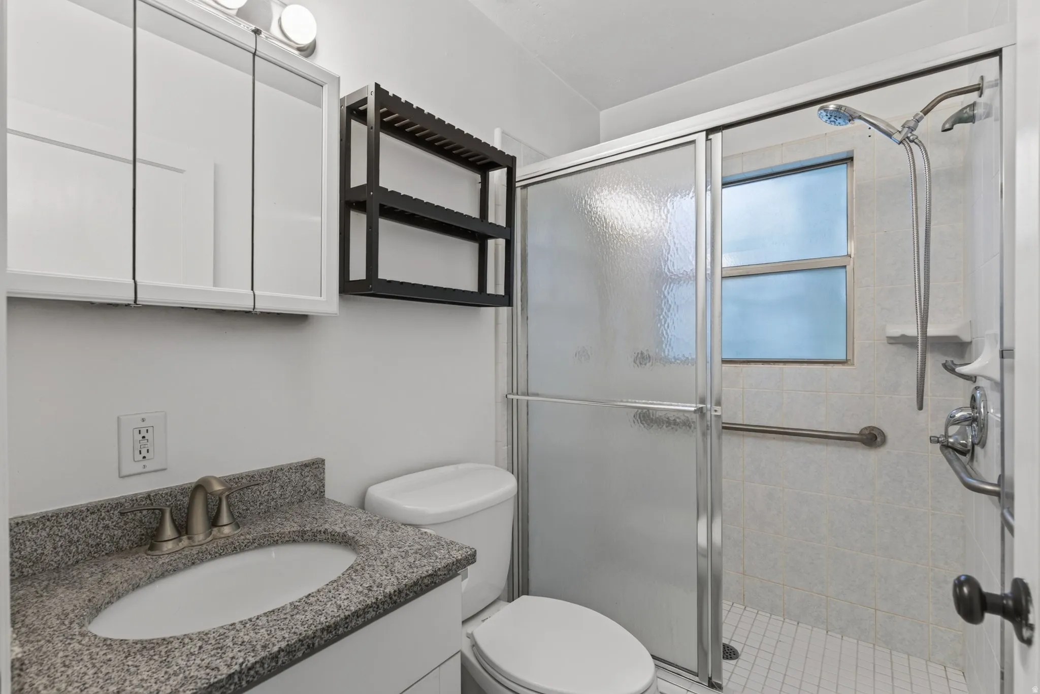 Bathroom featuring a granite countertop vanity with an undermount sink, brushed nickel faucet, white cabinetry, and overhead lighting