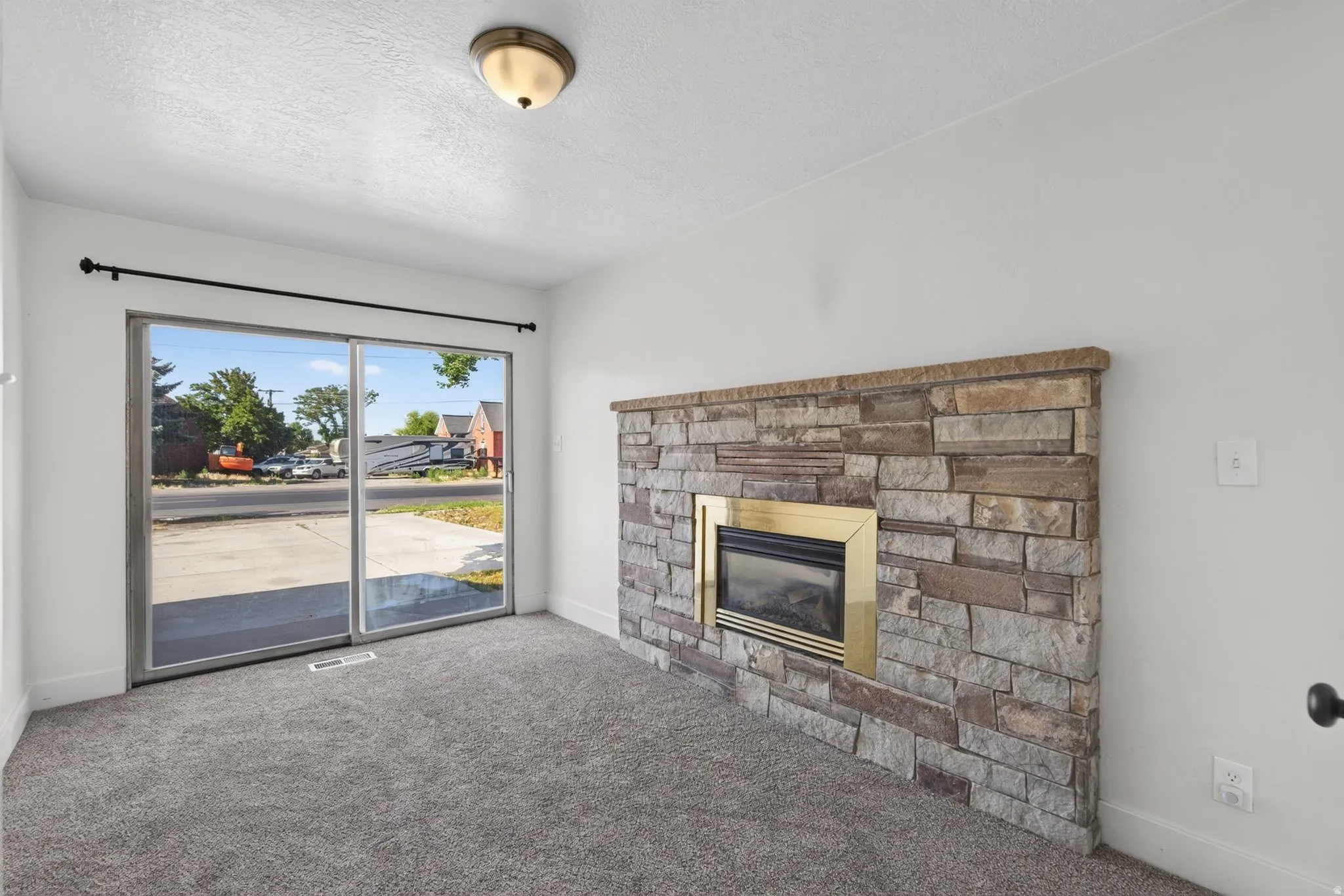 Stone-clad corner fireplace with a brass-finish insert