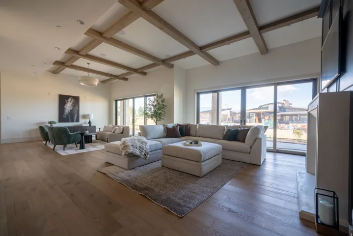 Wood-finish flooring throughout, exposed ceiling beams, built-in fireplace, and expansive glass sliding doors