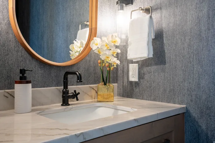 Built-in vanity with an integrated rectangular sink, light-toned countertop, and dark-finish faucet