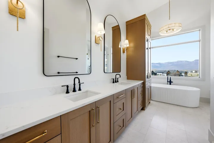 Dual vanity with undermount sinks, black fixtures, and gold-finish hardware