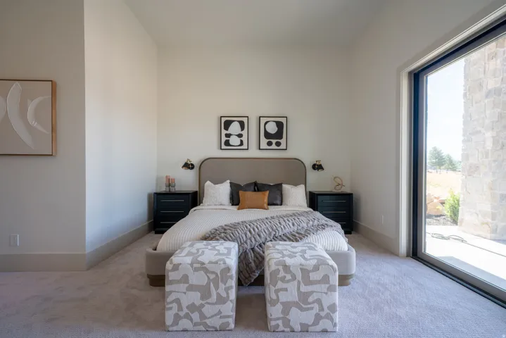Light-toned walls with high ceilings, featuring a full-height window with a dark frame