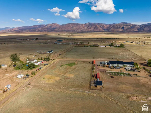 Expansive acreage featuring prominent mountain backdrop, open terrain, and multiple structures