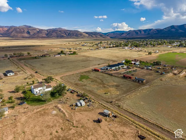 Aerial perspective featuring vast acreage, rural terrain, and mountain backdrop