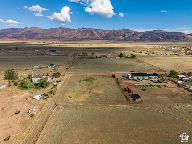 Expansive acreage featuring dirt road access and prominent mountain range backdrop