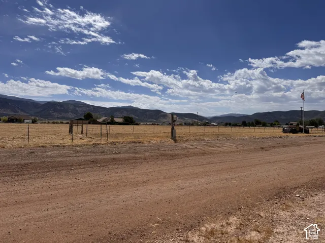 Expansive open land with a dirt road entrance