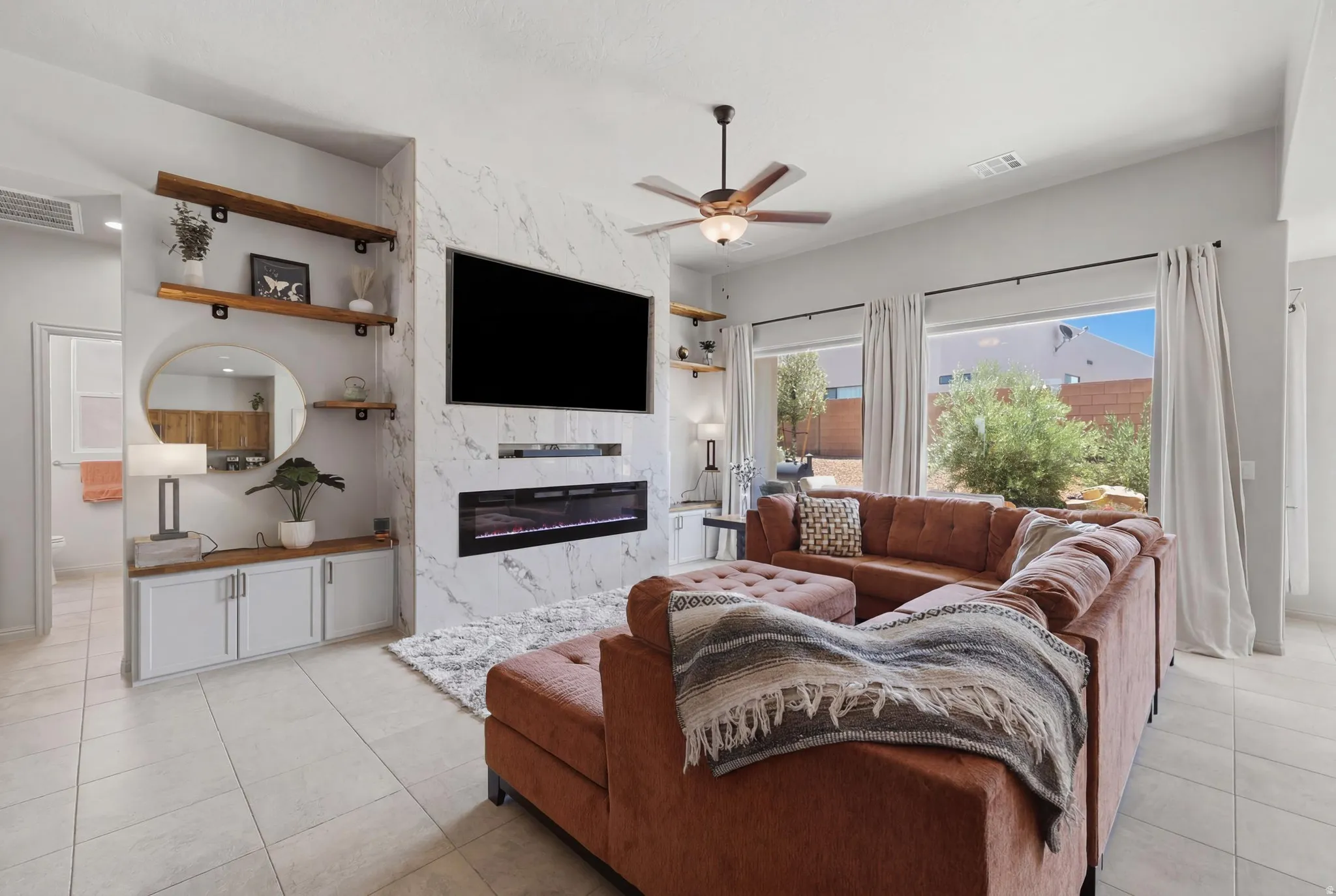 Living area featuring a floor-to-ceiling accent wall with a built-in electric fireplace and media niche