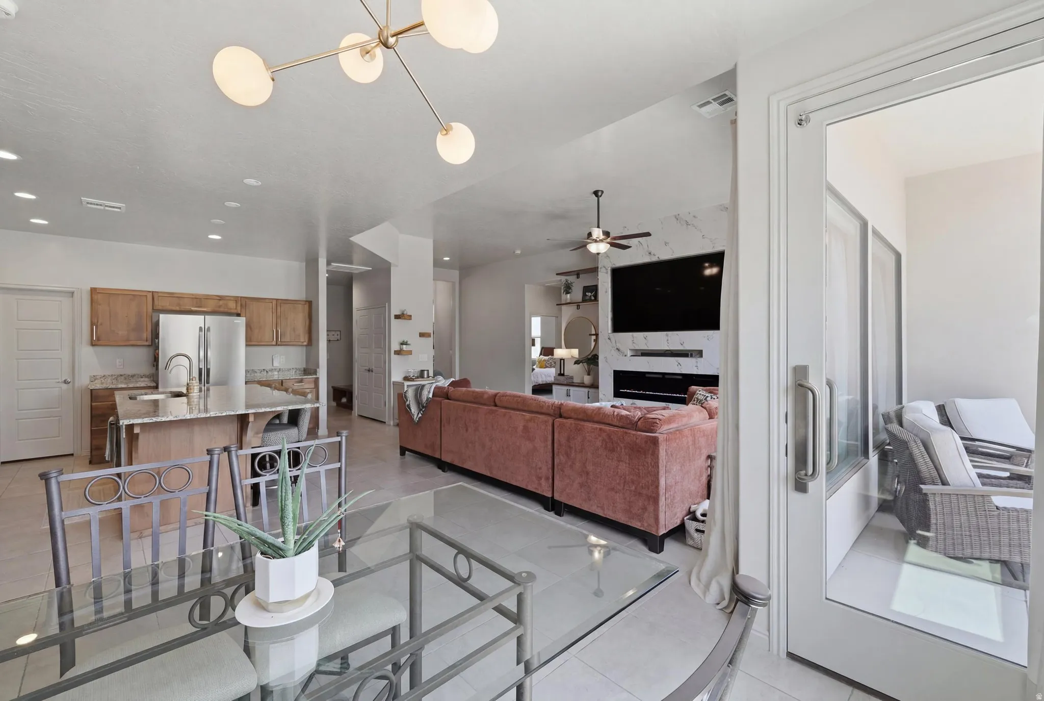 Open-concept living area featuring a kitchen with wood cabinetry, a central island, and stainless steel appliances