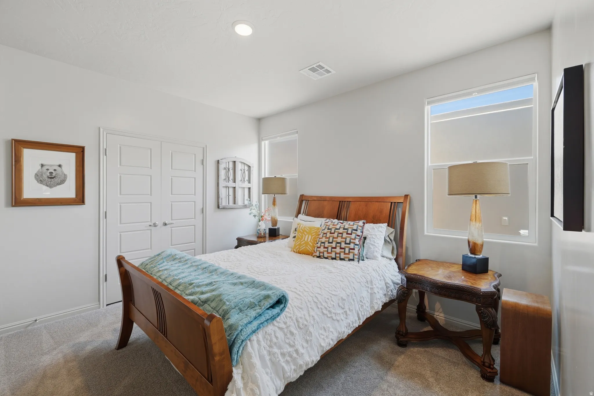 Plush carpeted bedroom featuring dual windows, recessed lighting, and a double-door entry