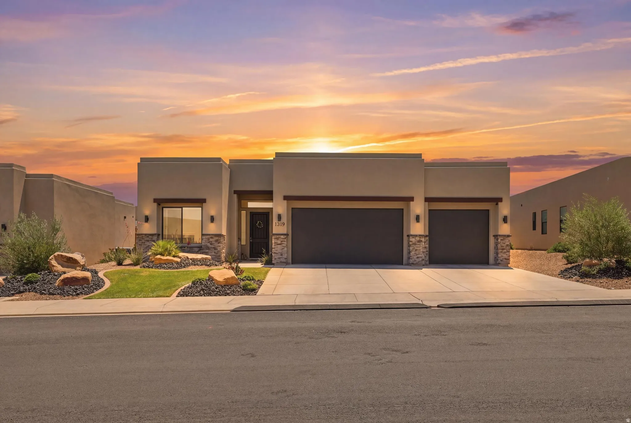 Contemporary stucco exterior with stone accents and a two-car garage