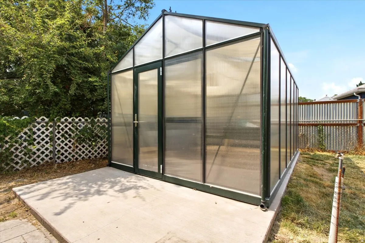Freestanding greenhouse structure featuring a metal frame and translucent panels