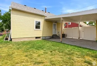 Carport structure with a paved driveway and privacy fencing