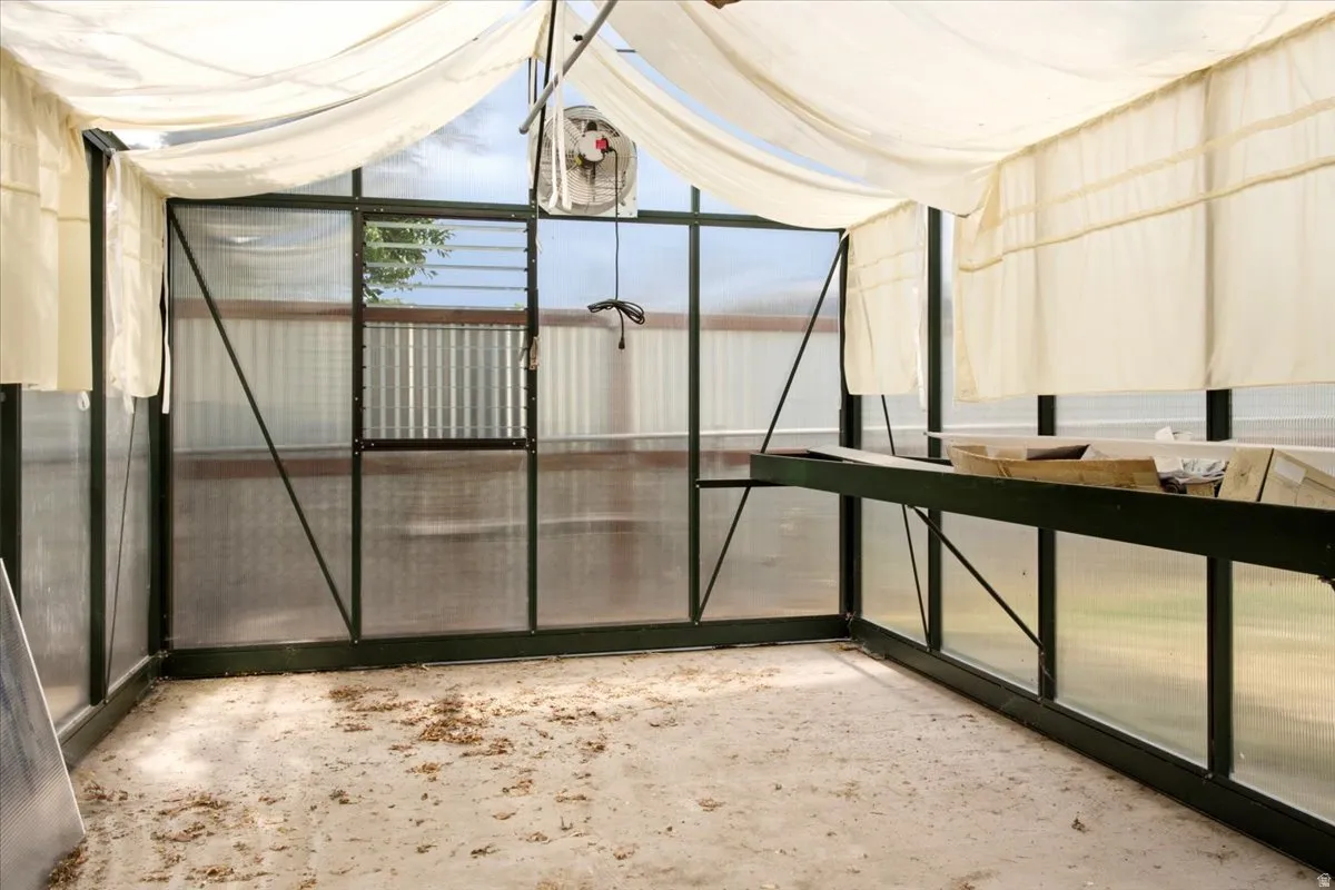 Greenhouse interior featuring a concrete floor and translucent panel walls