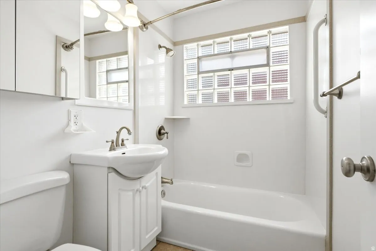 Bathroom featuring a white vanity with integrated sink, brushed nickel faucet, and coordinating cabinet hardware