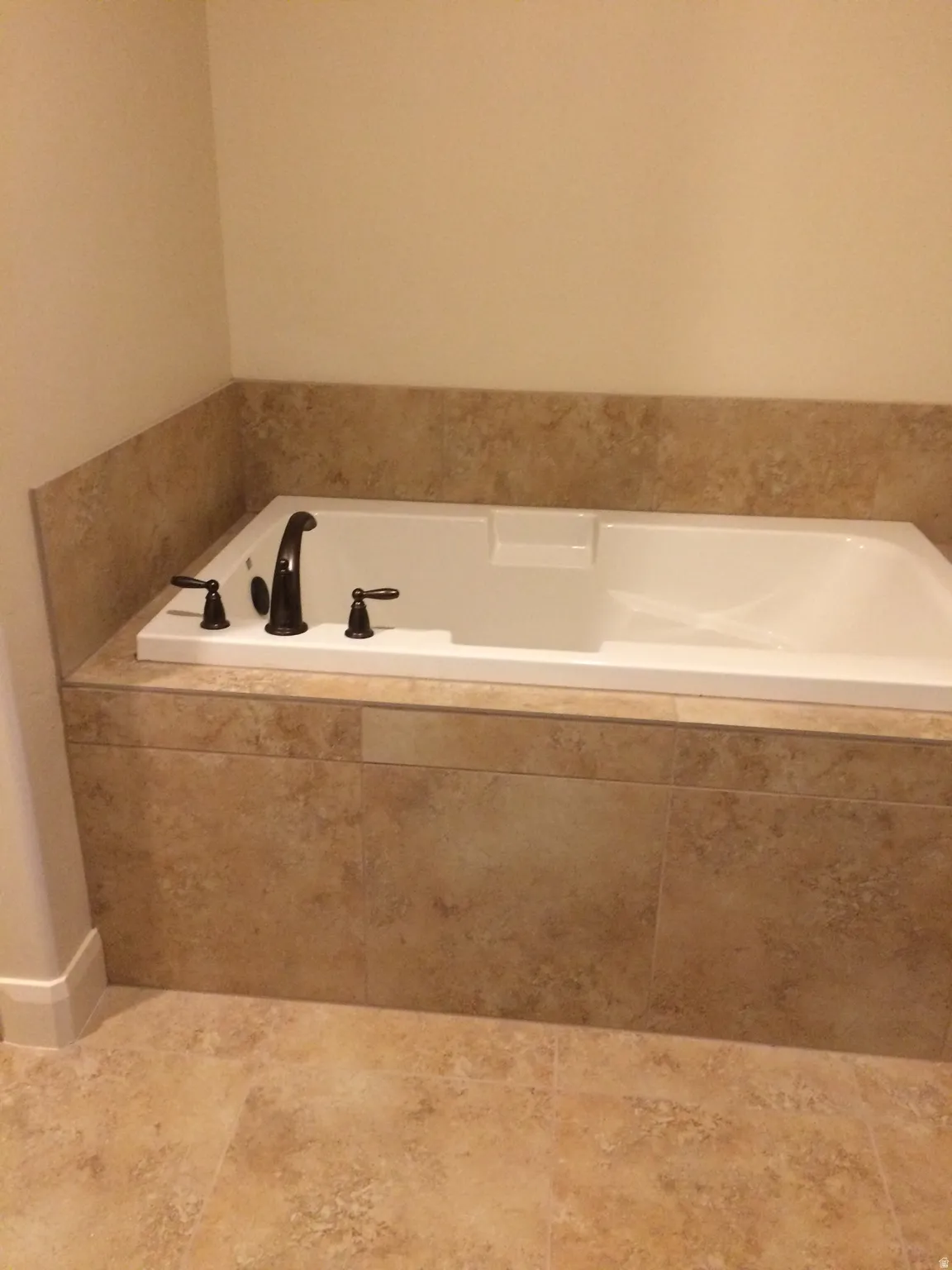 White built-in soaking tub with dark bronze fixtures