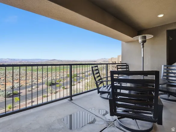 Covered balcony featuring concrete flooring and a black metal railing