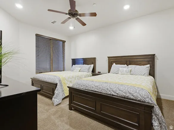 Carpeted room featuring two wood-finish platform beds with matching headboards