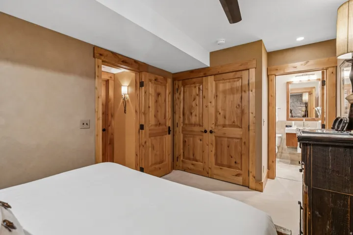 Bedroom featuring knotty wood doors, trim, and a ceiling fan